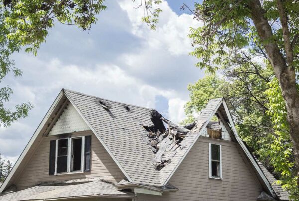 Difference in Conditions Insurance - Close-up of the Roof of a House That Has Collapsed under Blue Sky with Clouds on a Sunny Day