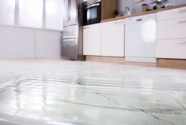 Flood Insurance - Close-up View Looking Up From a Flooded Wet Floor in a Modern Kitchen With Background Blurred