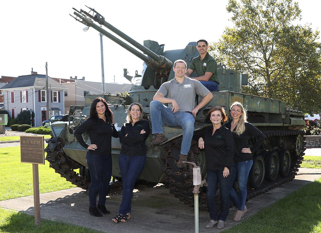 Agency Photo - Frederick Agency Inc. Team Leaning and Sitting on a Tank on a Sunny Day