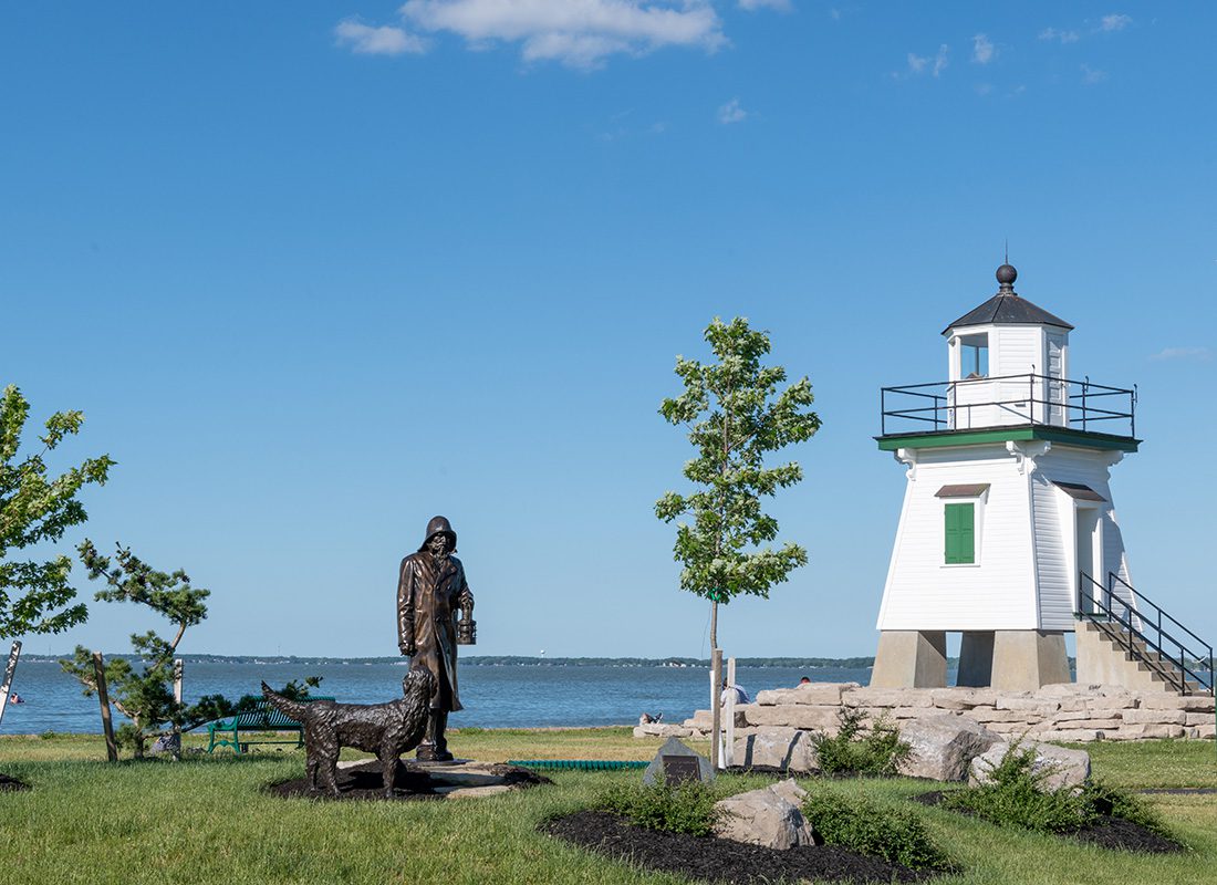 Contact - Port Clinton Lighthouse in Port Clinton, Ohio Displaying a Metal Statue and a Lake on a Sunny Day