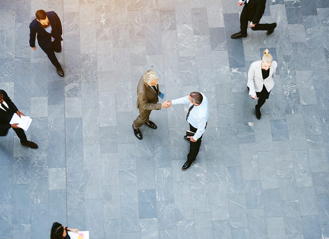 Insurance Solutions - Overhead View of Business People Walking and Shaking Hands in a Lobby